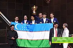 Six people standing behind a flag with three people standing in front of it next to a podium