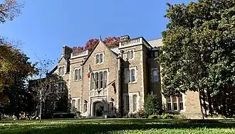 Photograph of a large brick house and the front lawn