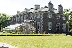 The rear of Government House, greenhouses, and surrounding garden