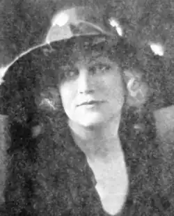 A young blond woman wearing a hat with a wide brim