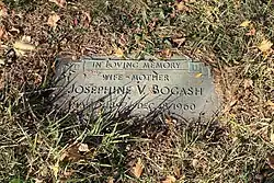 Flat memorial marker in a cemetery. The text reads "In loving memory, wife - mother, Josephine V. Bogash, March 3, 1897-December 18, 1960).