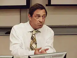 Guy Standing in 2014, sitting behind a computer and facing right