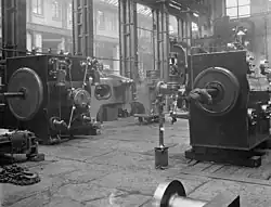 Cross compound Corliss mill engine 1900, shop assembled to ensure that the parts fit together and make any preliminary adjustments, the low-pressure cylinder is on the left, high-pressure cylinder on the right.[80][120]