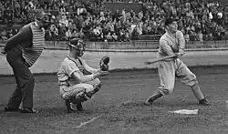 Black and white photo of Han Urbanus swinging at the plate in a 1954 game between a Dutch team and a team of U.S. Air Force personnel in Haarlem, the Netherlands