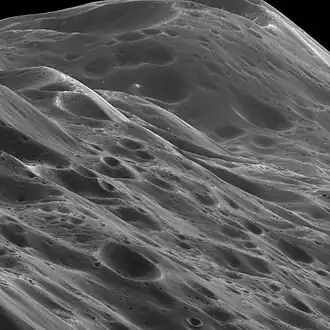 Image 7 Iapetus Photo credit: Cassini orbiter A close-up of 10 km (6.2 mi) high mountains within the equatorial ridge on Saturn's moon Iapetus, photographed by the Cassini orbiter. Above the middle of the image can be seen a place where an impact has exposed the bright ice beneath the dark overlying material. The image was taken on September 10, 2007, with the Cassini spacecraft narrow-angle camera at a distance of approximately 3,870 km (2,400 mi) from Iapetus. More selected pictures