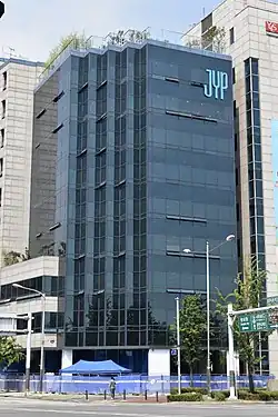 An image of a building with the text "JYP" on the upper side.