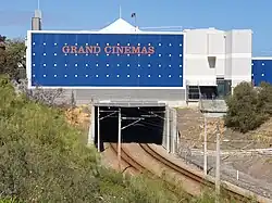 A railway line entering a tunnel under a shopping centre