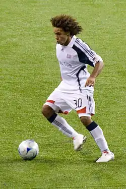 A soccer player dribbles the ball.