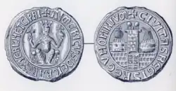 Photo of two ancient silver circular seals of Aimery, with Latin words framing the outer part of the seals.
