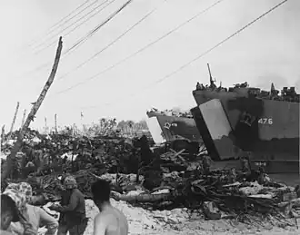 US Navy ship USS LST-476 and USS LST-479 land vehicles and supplies at Roi Island in February 1944