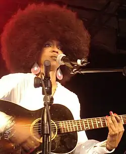 Lauryn Hill playing the guitar.