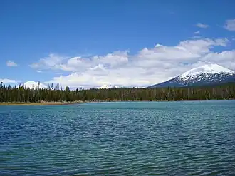 View to the northeast across Lava Lake with three volcanic mountains in the background: South Sister, Broken Top, and Mount Bachelor.