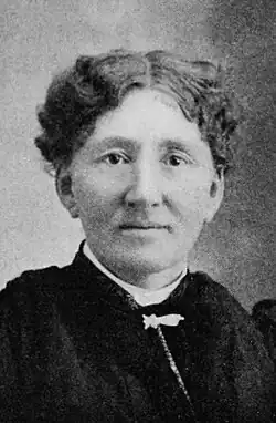 Photograph of woman with short wavy hair, looking straight into camera