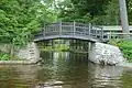The arched Lily Pond Foot Bridge crosses its inlet on Brantingham Lake, New York