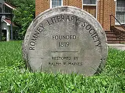 A round stone monument commemorating the establishment of the society