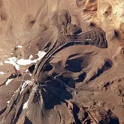 A mountain with large tongue-like lava flows protruding from it