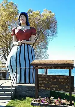 larger than life fiberglass statue of an adult woman in a striped dress