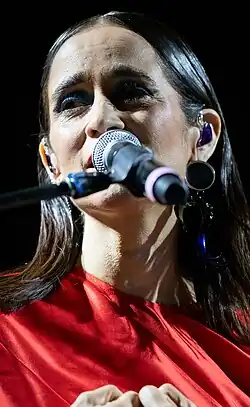 Closeup image of Julieta Venegas performing in front a microphone