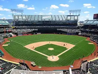 View of a baseball stadium, taken from the upper deck and looking out over the field from center field. Open roof