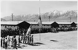 Memorial Day services at Manzanar Camp in 1942 with Boy Scouts performing the flag ceremony