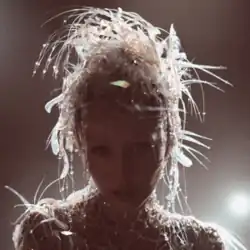 Cyrus looking forward with a shining light behind her