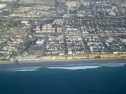Aerial view of part of old town Encinitas showing Moonlight Beach on the left. Parallel with the shore is Historic Coast Highway 101; also parallel and further inland is Interstate 5.
