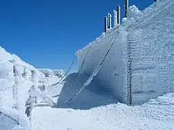 The original weathered shingle-clad building is chained to the ground, here covered in rime ice in early April.