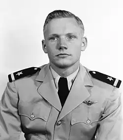 A black-and-white image of a light-skinned man in his early 20s. He is looking off to his right. He has mid-colored hair parted to the right. He wears a light-colored military uniform with an eagle badge on the left chest. His epaulettes are dark and have a light bar and star. He has a white shirt and a dark necktie.
