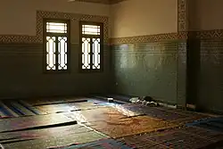 A room with a patterned wood window.