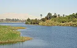 A color photograph of a river and its tree-covered banks