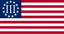 Flag shown as a horizontal rectangle with thirteen alternating red and white horizontal stripes; blue rectangle in upper left corner displays Roman numeral III in the center of a circle of thirteen white five-pointed stars