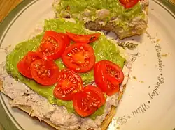 Open-faced tuna sandwich with guacamole and cherry tomatoes