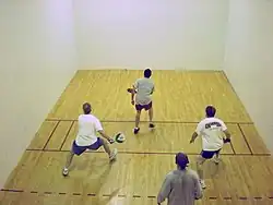 Four men playing paddleball