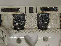 Detail of the masks on the settle, group above