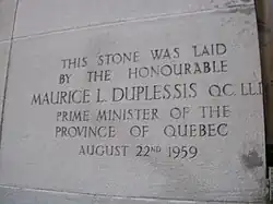 A stone saying "This stone was laid by the honourable MAURICE L. DUPLESSIS QC LLD, Prime Minister of the Province of Quebec. August 22nd, 1959"