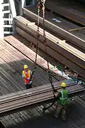 Labor union workers unload structural steel from the hold of a ship