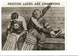two women putting on hockey equipment