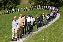 Artist Hamish Fulton leading a single-file line of walkers