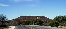Round Mountain, a butte located 6&nbsp;mi (9.7&nbsp;km) to the northwest of Comanche, Texas, where Robert T. Hill first observed Lower Cretaceous fossils and strata. (31°55′30″N 98°42′07″W﻿ / ﻿31.925°N 98.702°W﻿ / 31.925; -98.702) (30 December 2008)