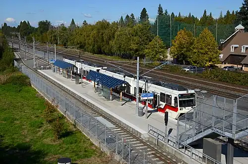 A MAX train stopped at SE Bybee Blvd station seen from above on the Bybee Bridge