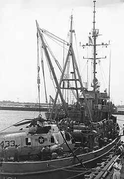 USS Salinan (ATF-161) in port, with an SH-3 Sea King helicopter on her deck, June 1976. She had recovered the helicopter from seventy feet of water after it crash-landed and sank ten miles off the coast of Ponte Vedra, southeast of Mayport, Florida. The aircraft belonged to Helicopter Antisubmarine Squadron One (HS-1), based at Naval Air Station Jacksonville, Florida.
