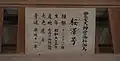 A wooden plaque with Japanese writing listing information about a donated shinme.