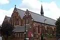 St Thomas's Church, Islington, London, 1888–89 by Ewan Christian, view of west front and south aisle showing Early English style lancets and narthex below the west windows[160]