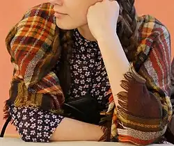 Estonian woman wearing a tartan suurrätt (plaid/shawl)