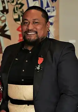 head and shoulders of Tanu smiling at the camera, on his suit jacket is a medal
