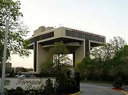 A futuristic, one-story building is elevated on two concrete columns.