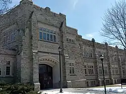 Three-storey building constructed with a sandstone exterior, and an archway over the front entrance