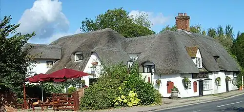 English pub names such as The Barley Mow (like this pub at Clifton Hampden) allude to the use of barley to make the beer available inside.[102]