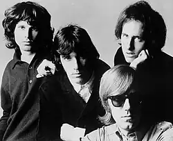 The Doors c. 1966: Jim Morrison (left), John Densmore (center), Robby Krieger (right), and Ray Manzarek (seated)