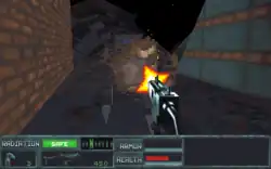 A horizontal rectangular video game screenshot that is a digital representation of an alleyway in a destroyed city. A gun, pointed away of the viewer and towards the center of the screenshot, fires at a robot. The lower portion of the screen features a dashboard with colored bars with accompanying text, "Radiation: Safe", "Armour", and "Health", as well as grenade and gun icons next to the numbers three and 450, respectively.